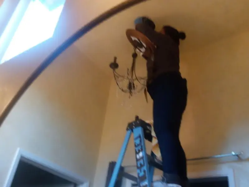 Electrician installing a chandelier in a Cuba residence